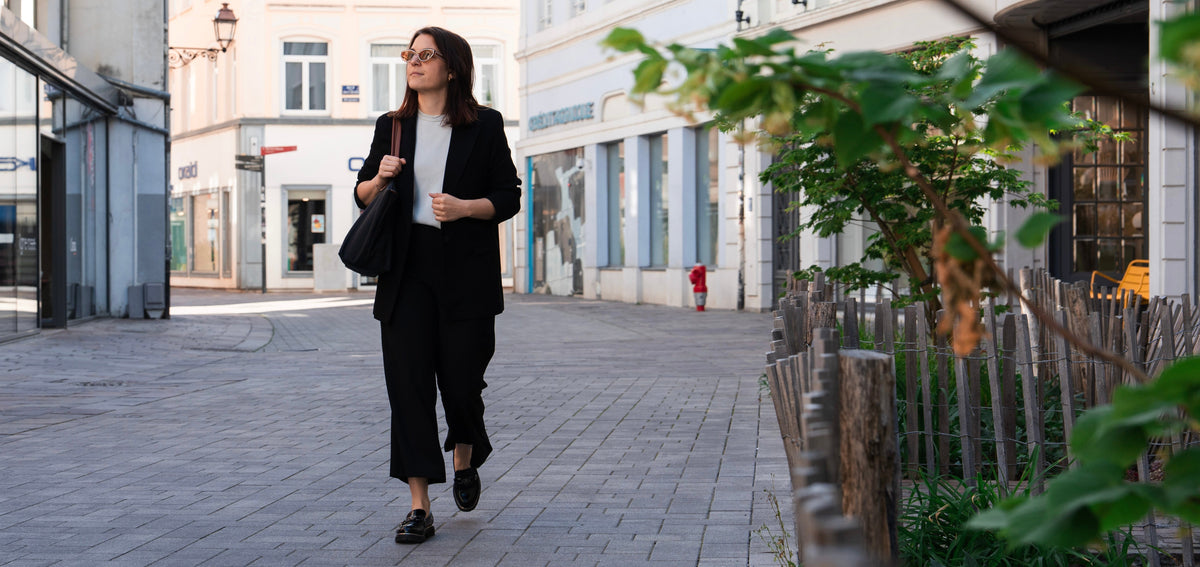 Femme active d'une quarantaine d'années, souriante et dynamique en ville, illustrant la vitalité et la confiance retrouvées grâce à une approche de santé durable après 40 ans.