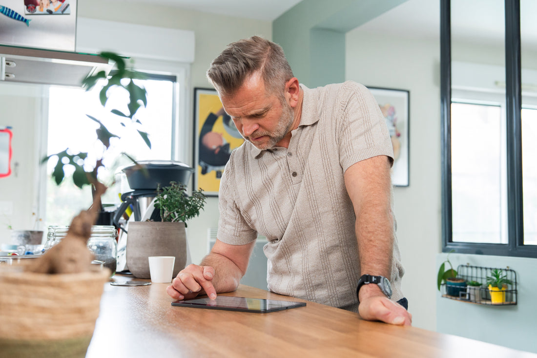 Homme actif de 50 ans consultant son programme de remise en forme, illustrant la reprise en main de sa santé biologique au quotidien.